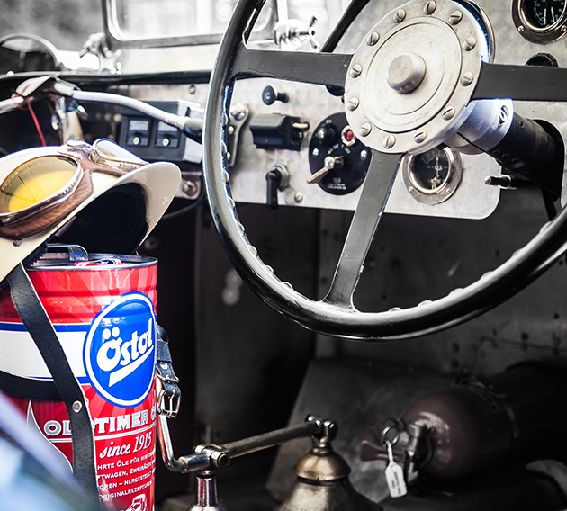 Ein Fahrraum eines Oldtimers indem neben dem Fahrersitz eine Dose Östol Oldtimer Öl steht und mit der roten Farbe farblich heraussticht.